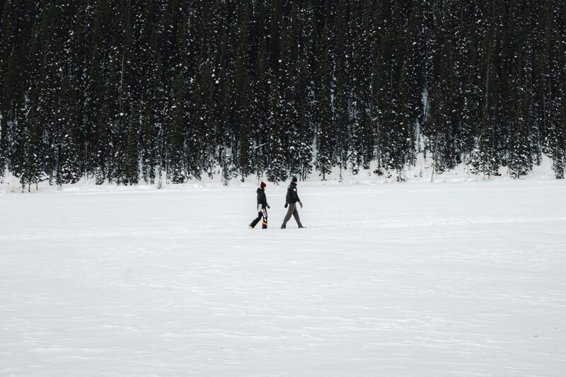 Two people walking in snowy field