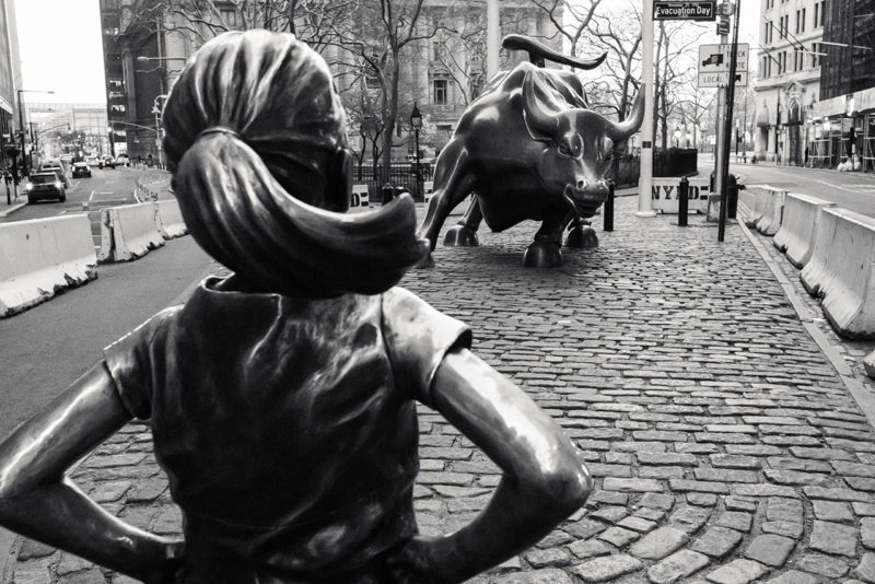 Girl Staring Down Bull Sculpture on Wall Street