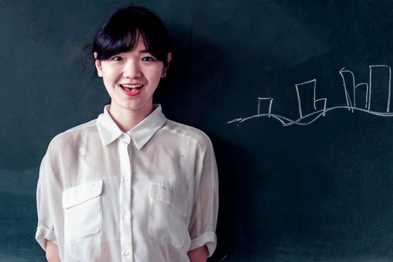 Student at blackboard in classroom