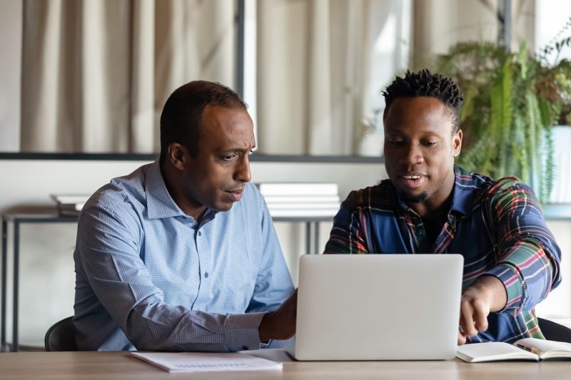 Two black men working at computer