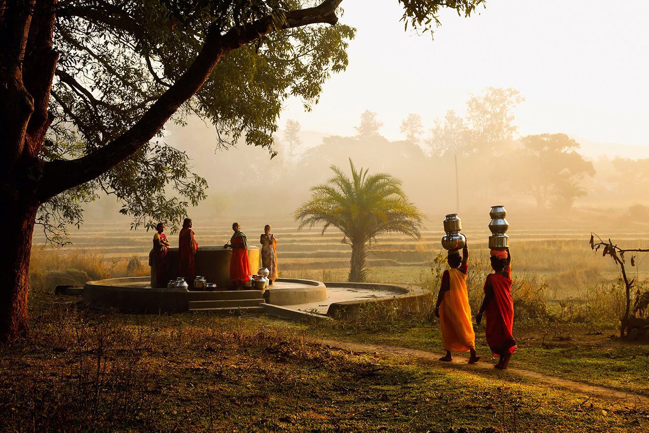 Women in traditional dress carrying water