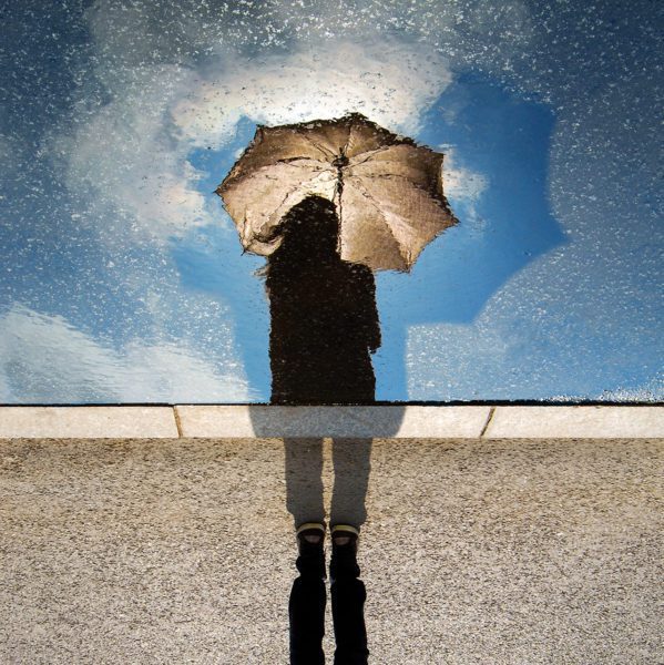 Person with umbrella shielding sun