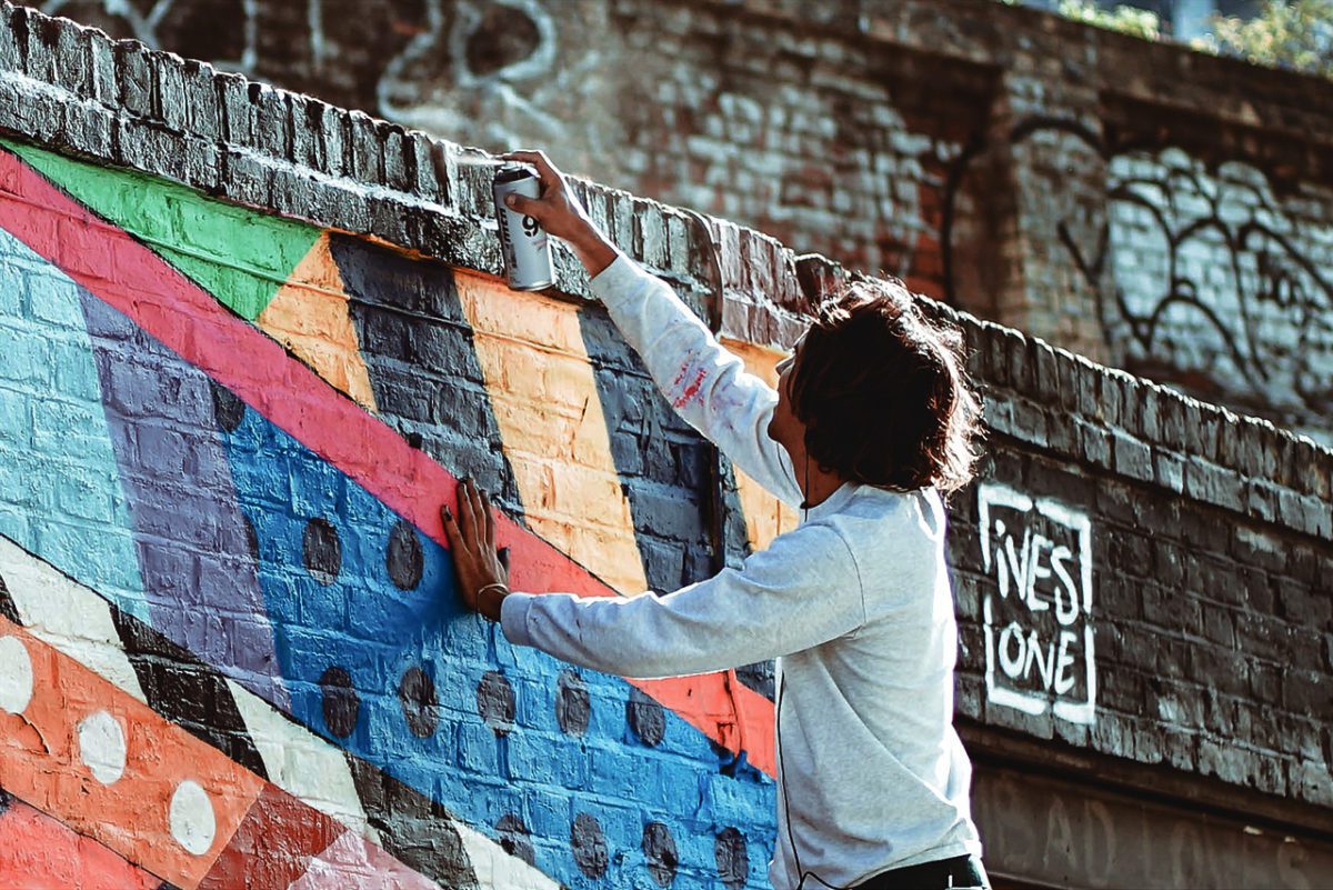 Wpman spraypainting LGBTQ+ mural