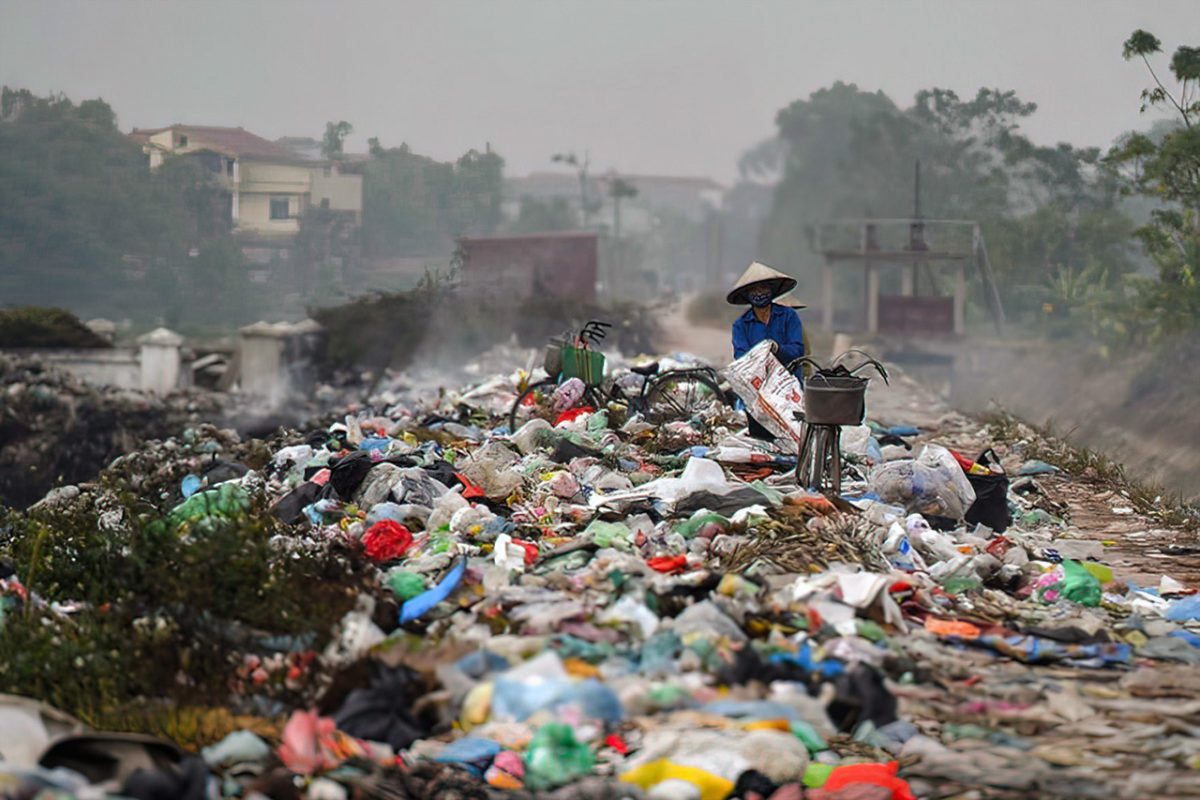 Asian worker standing in plastic waste