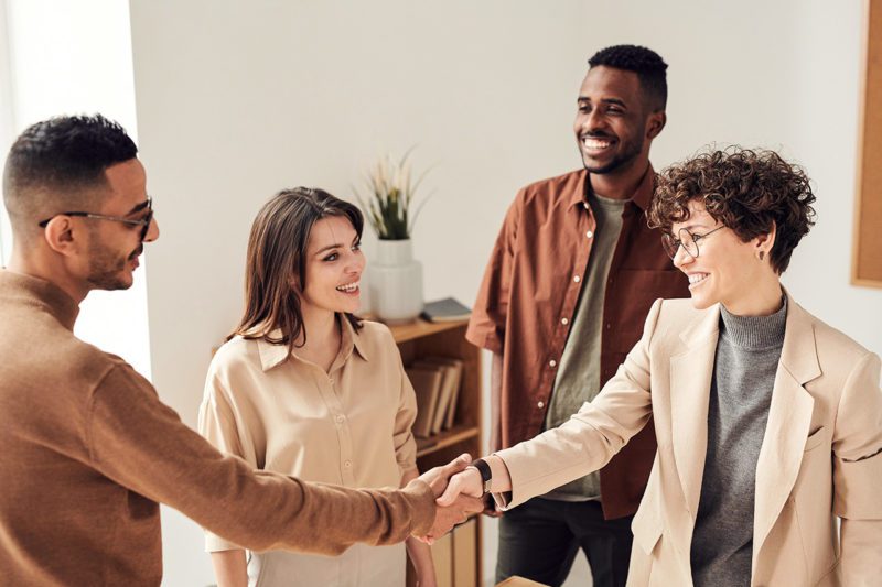 Diverse workers greeting each other
