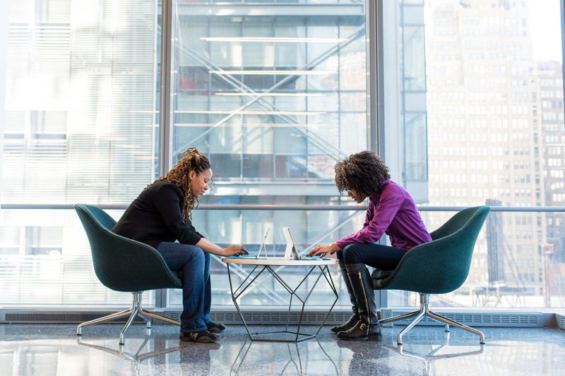 Two women in a glass office