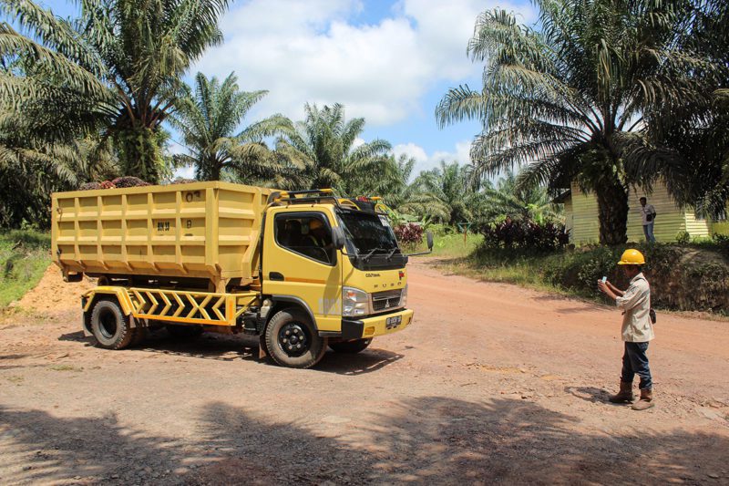 Palm oil plantation staff using eKomoditi application to keep a record of internal driver and vehicle shipment details for each truck