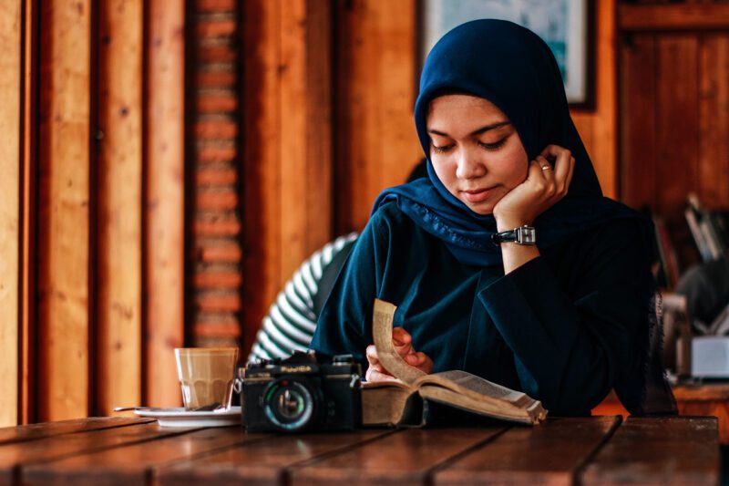 Muslim woman at work reading book