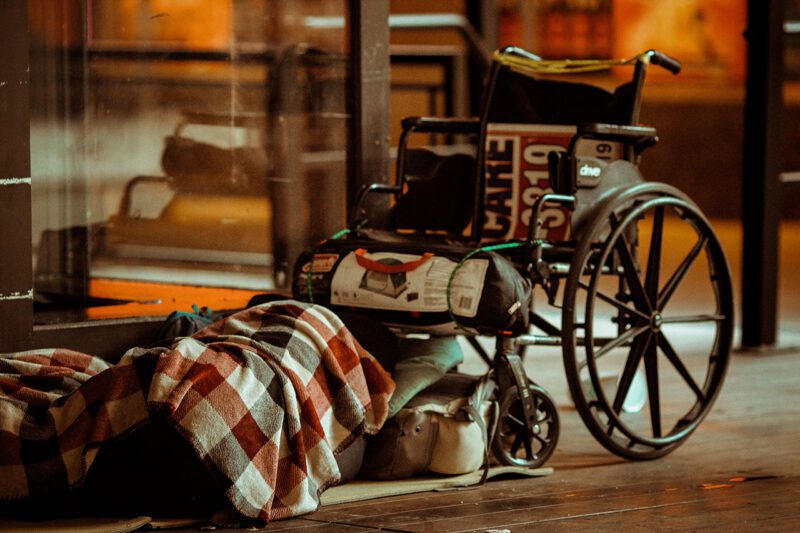 Homeless man at foot of wheelchair
