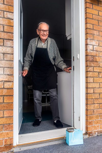 Elderly man at door of home