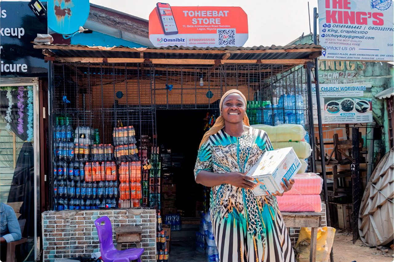 Nigerian woman entrepreneur in front of store