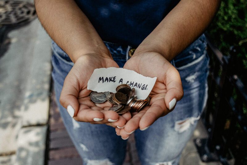 Hands holding coins and Make a Change sign