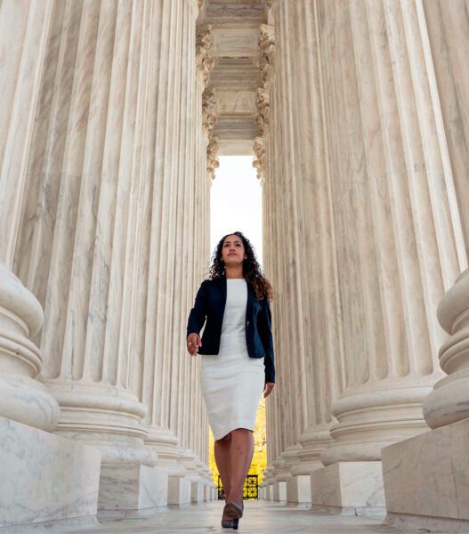 Professional woman walking through capital arches