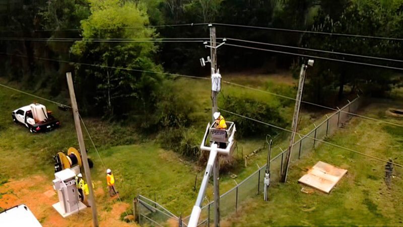 Crew hanging fiber on street pole