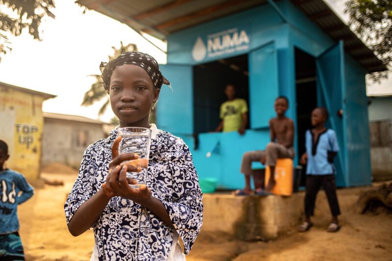 Child im Africa holding glass of clean water