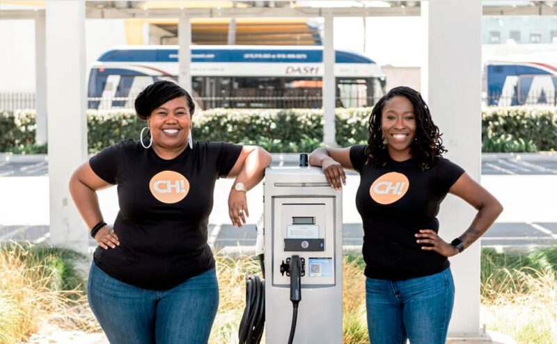 Two black female entrepreneurs with EV charger