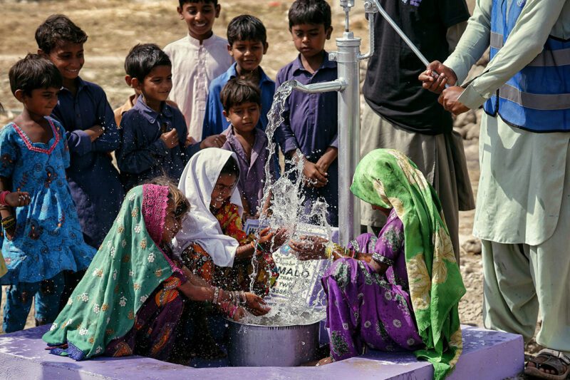 South Asian women and children filling water containers