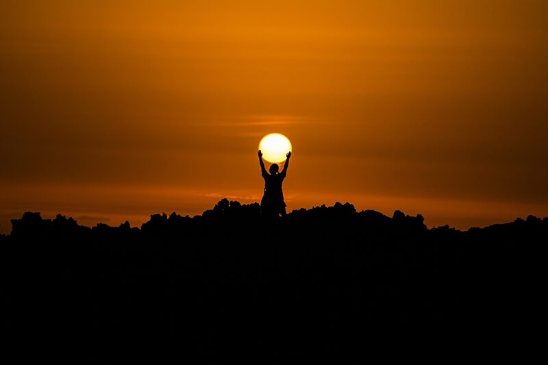 Man holding sun in his hands