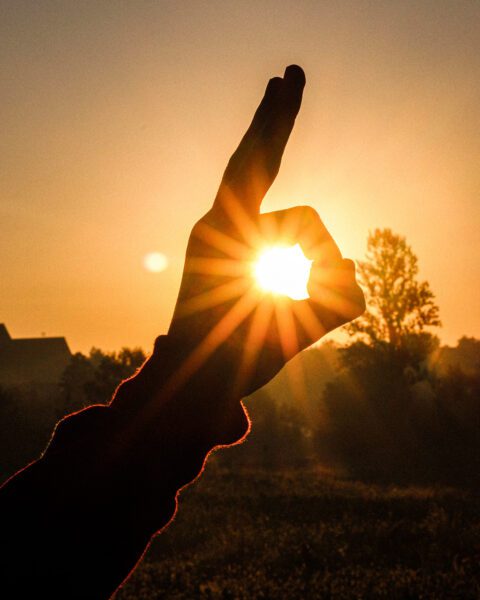 Sun between hand's fingers