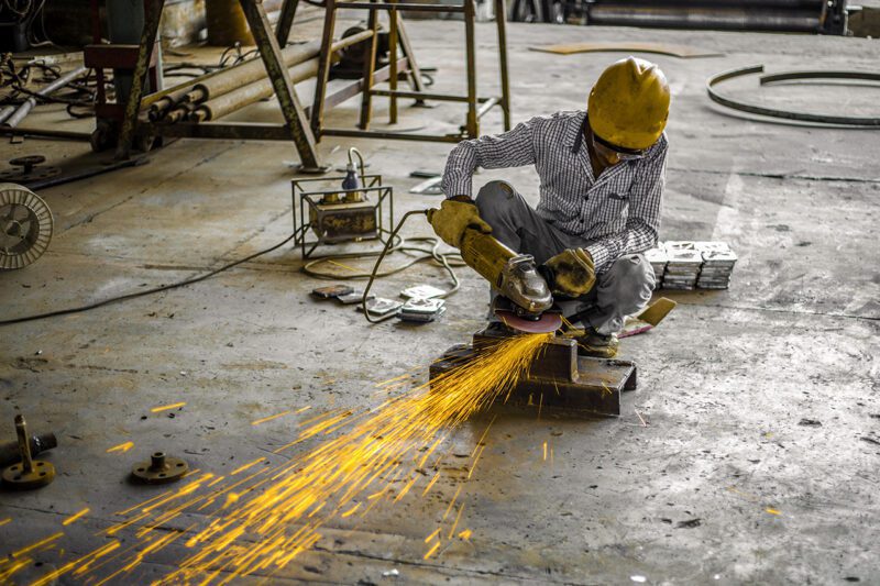 Hard hat worker with machine shooting sparks