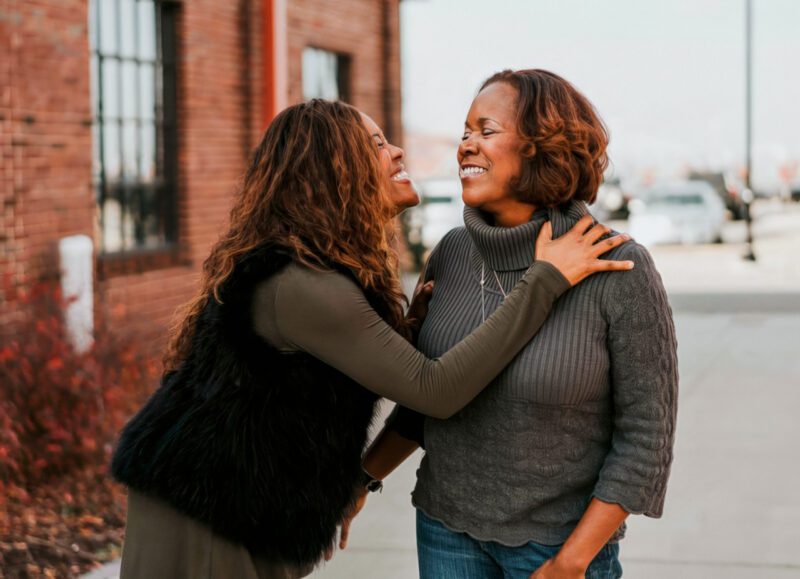 Two black women smiling at each other