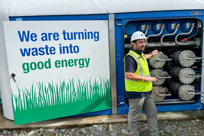 Renewable energy worker in front of sign