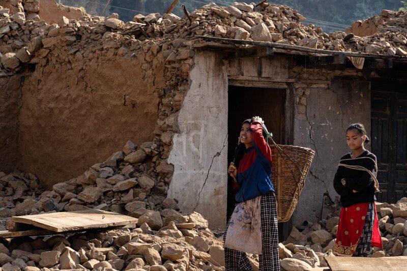 Nepalese women in front of earthquake destroyed homes.