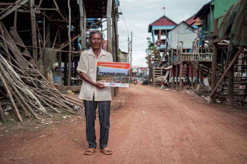Cambodian man holding picture in street