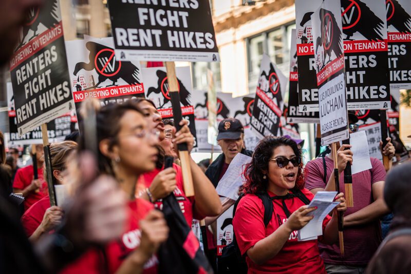 Protesters holding Renters Fight Rent Hikes signs
