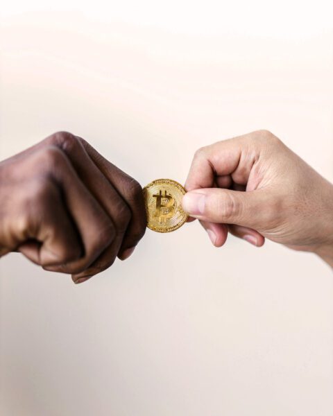Black and white hands holding bitcoin
