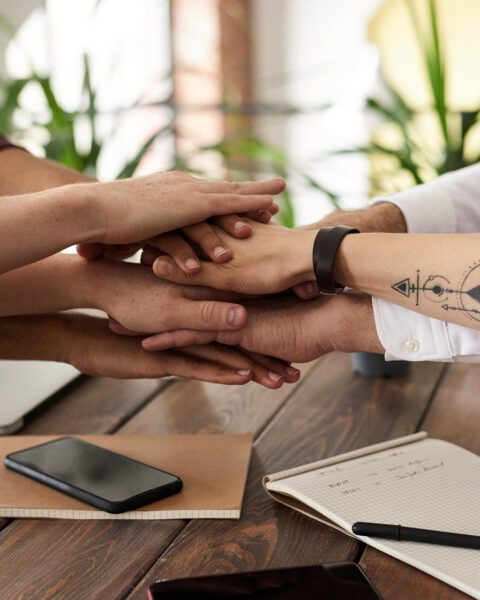 Workers' hands together in celebration