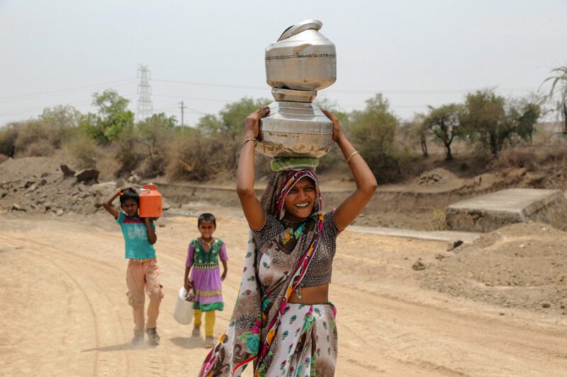 Indian woman carrying water jugs on head