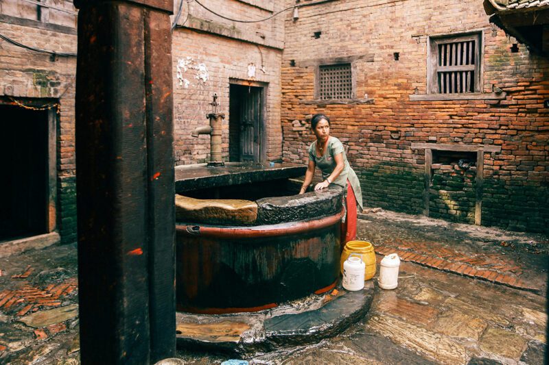 Woman gathering water at courtyard well
