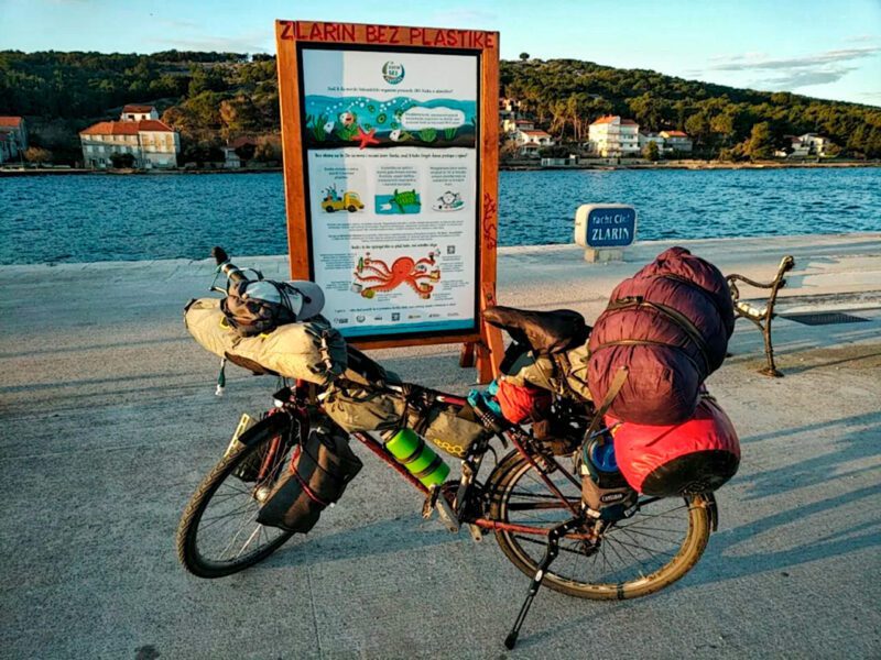 Bike next to billboard and sea