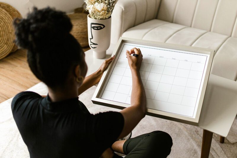 Woman writing on note board in her home