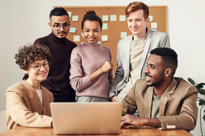 5 diverse professionals looking at laptop