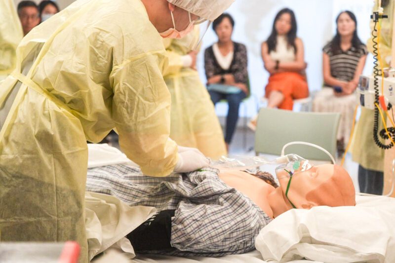 Instructor teaching medical students on dummy patient