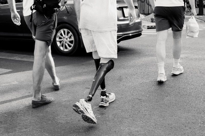 Veteran walking with prostheics on street