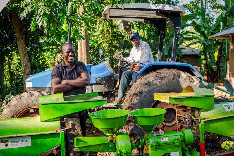 Two african farmers, one on tractor