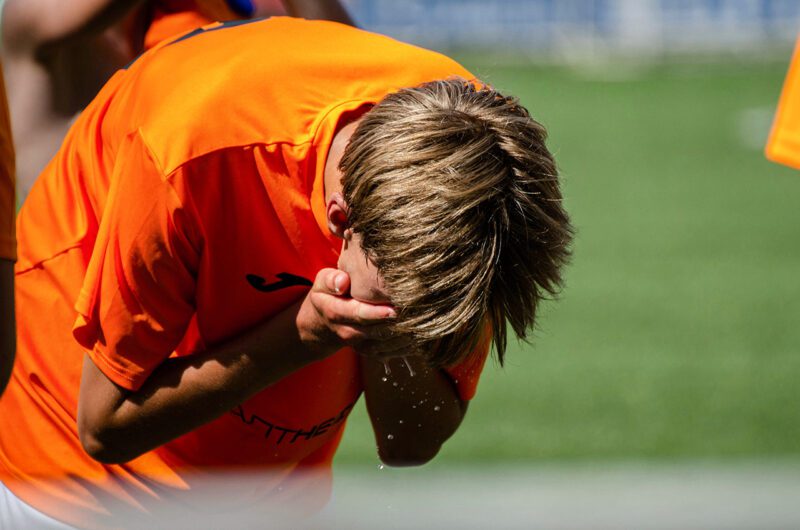 Soccer player bent over due to heat exhaustion