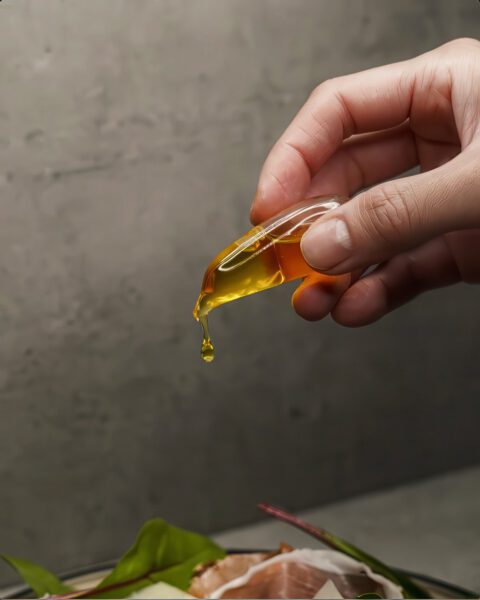 hand dripping oil on food.