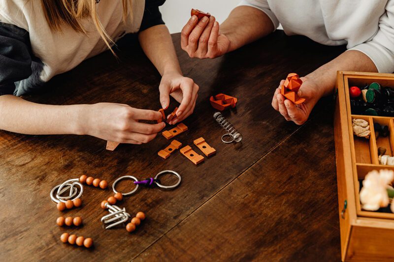 Hands of people working with various items on table