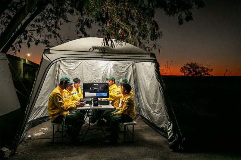 Firefighters gather under field tent