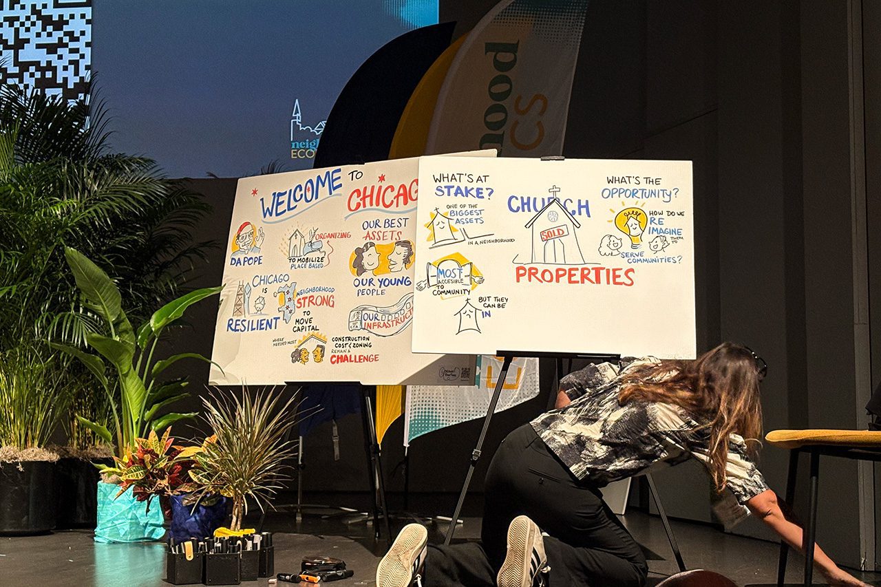 Woman and posters on Neighborhood Economics stage