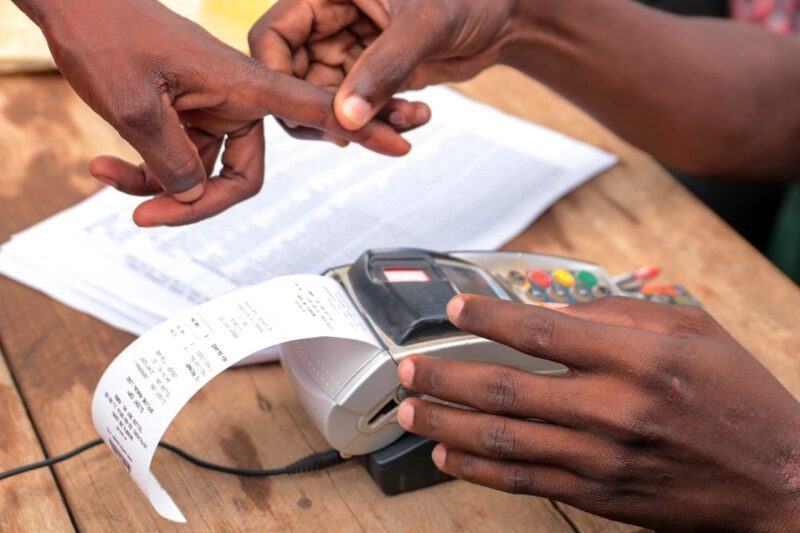 Hands around biometric payment machine