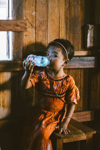 Latin American girl drinking from water bottle