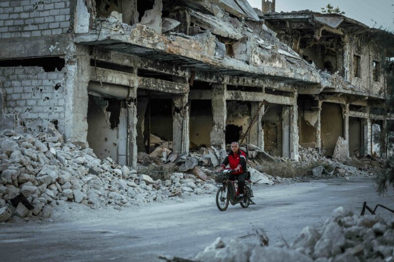 Man on motorbike in ruined city