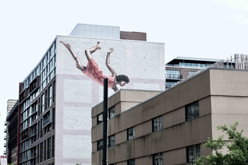 Mural of woman levitating on city building