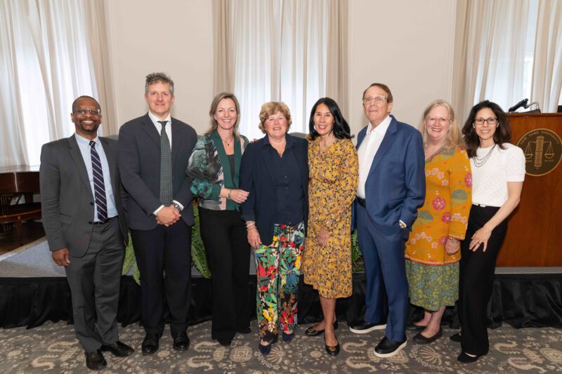 Eight participants in the 2026 Grunin Prize program stand together at NYU School of Law.