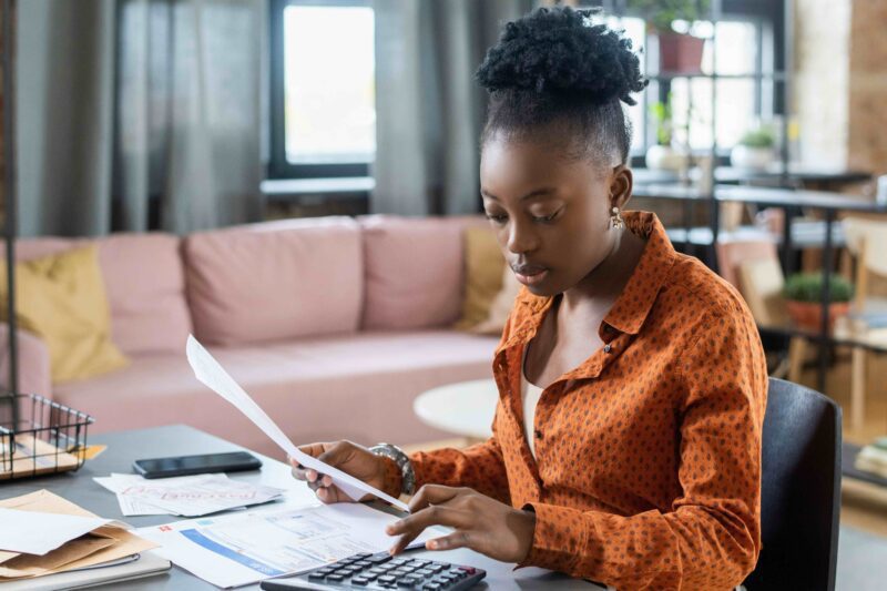Woman at desk with laptop and bills